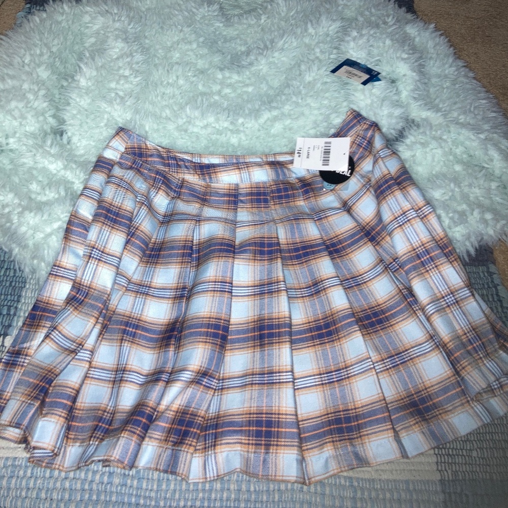 Pleated skirt, buttons and zips on the side New